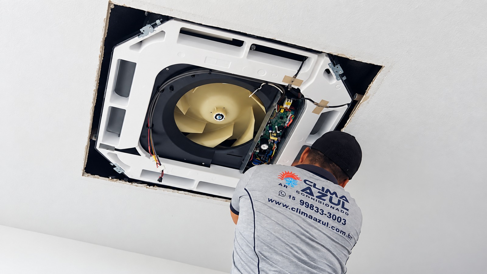 Técnico realizando higienização em ar-condicionado cassete